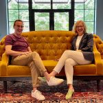 two people sitting on bright yellow couch